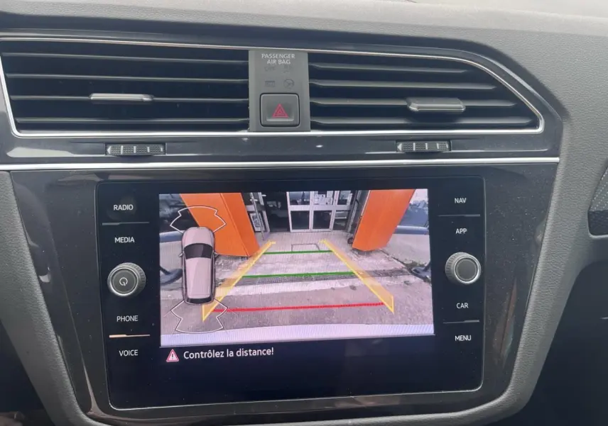 Écran tactile intérieur du Volkswagen Tiguan 1.4 eHybrid montrant la caméra de recul avec guidage coloré.