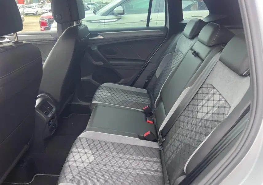 Vue latérale droite de l’intérieur arrière du Volkswagen Tiguan 2023 avec sièges tissu et cuir gris à motifs géométriques.