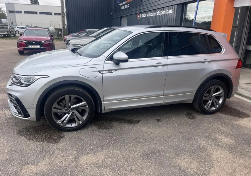Volkswagen Tiguan 1.4 eHybrid gris dauphin métallisé vu de profil côté gauche, jantes alu et vitres surteintées.