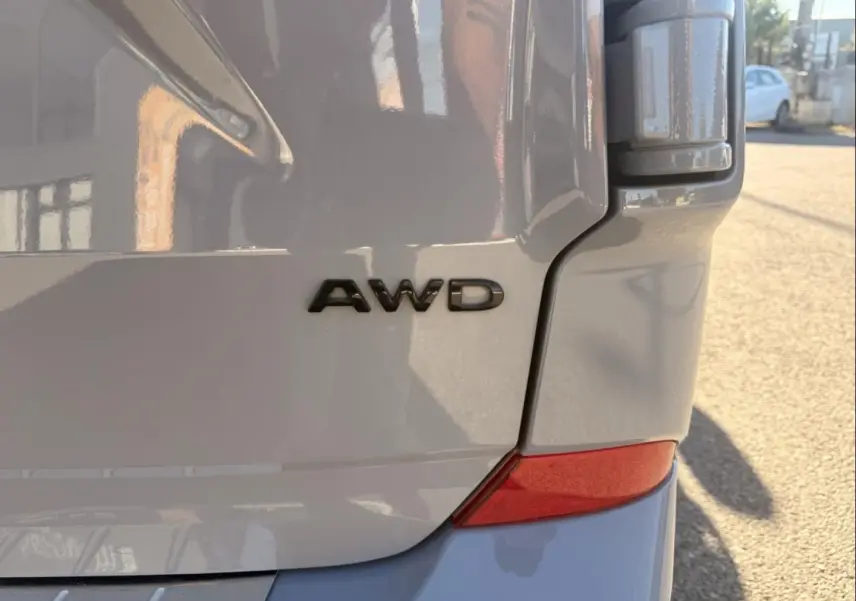 Gros plan sur l'arrière droit gris du Ford Transit Custom Fourgon 2024 avec le badge AWD visible.