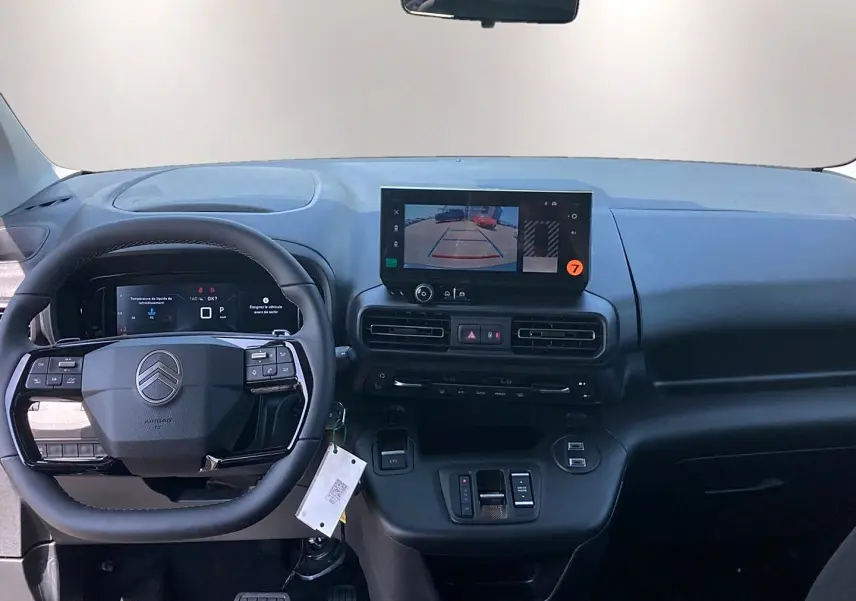 Vue intérieure avant du tableau de bord noir du Citroën Berlingo 2026 avec écran tactile et volant multifonction.