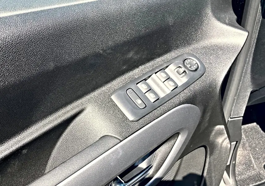 Gros plan sur la commande des vitres électriques côté conducteur du Citroën Berlingo noir, intérieur en plastique noir.