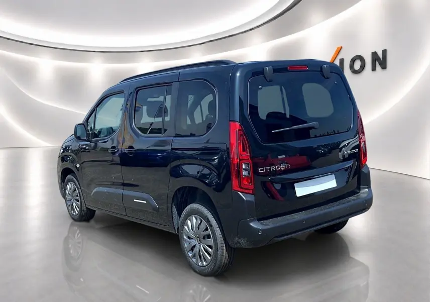 Vue 3/4 arrière droite d'un Citroën Berlingo noir 2026 avec barres de toit et vitres teintées.