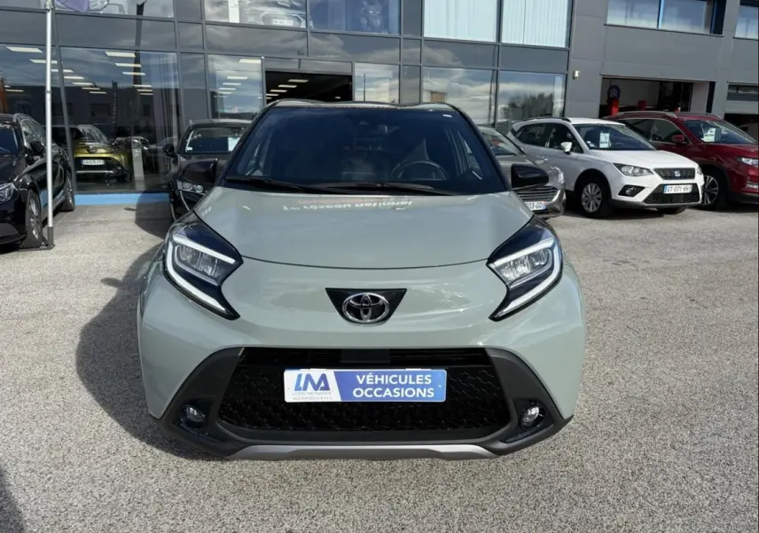 Vue avant frontale d'une Toyota Aygo X 2025 vert aventurine avec toit noir, mettant en valeur ses phares distinctifs et sa calandre noire.