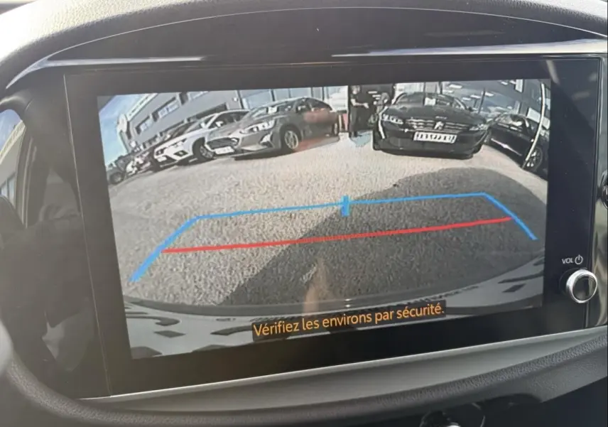 Vue de l'écran de caméra de recul d'une Toyota Aygo X 2025 vert aventurine avec toit noir, montrant les lignes d'aide au stationnement.
