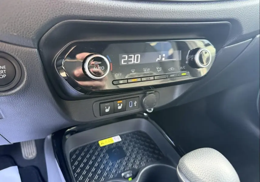 Gros plan sur la console centrale de la Toyota Aygo X 2025, montrant la commande de climatisation digitale et les boutons chauffants.