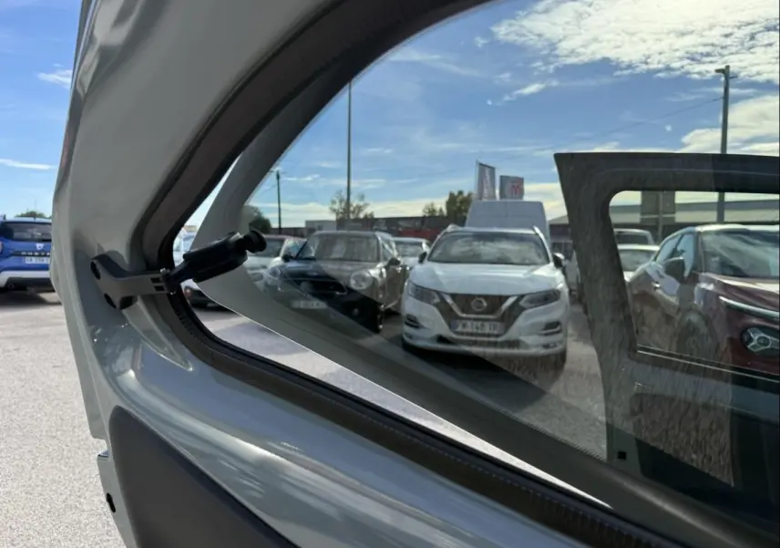 Vue partielle intérieure sur la portière arrière droite du Toyota Aygo X 2025 vert aventurine avec toit noir, montrant la vitre ouverte.