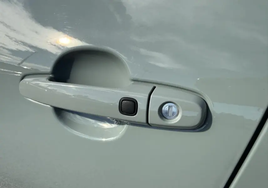 Poignée de porte avant droite de la Toyota Aygo X 2025 en vert aventurine avec bouton noir et serrure intégrée.