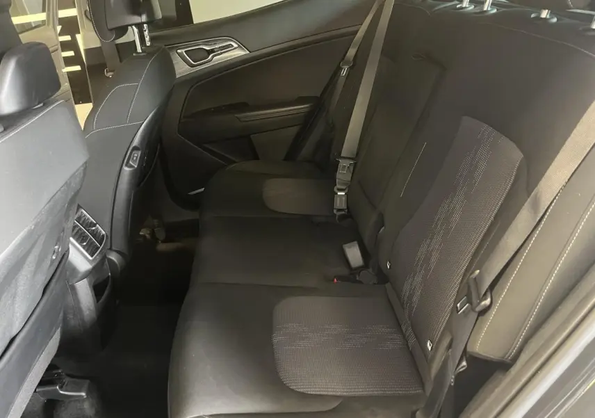 Vue latérale droite de la banquette arrière noire en tissu du Kia Sportage 2022 avec accoudoir central relevé.