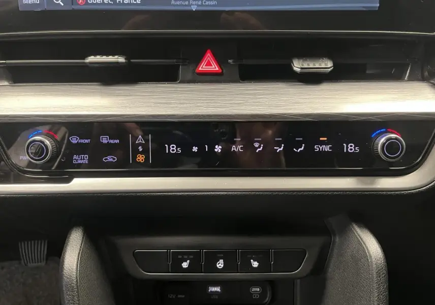 Plan rapproché du tableau de bord du Kia Sportage 2022 gris montrant la commande de climatisation automatique et les boutons chauffants.