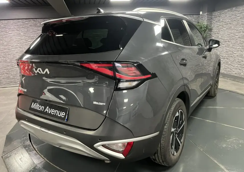 Vue 3/4 arrière droite du Kia Sportage gris métallisé 2022 avec feux arrière LED et jantes alliage 17 pouces.
