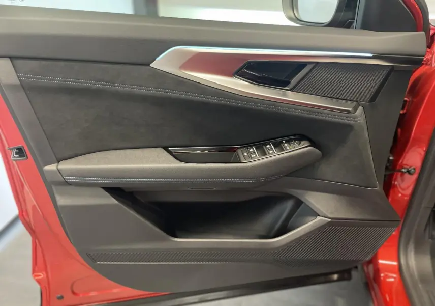 Vue latérale du panneau de porte avant gauche rouge métallisé du Renault Austral Esprit Alpine avec garniture noire et commandes électriques.
