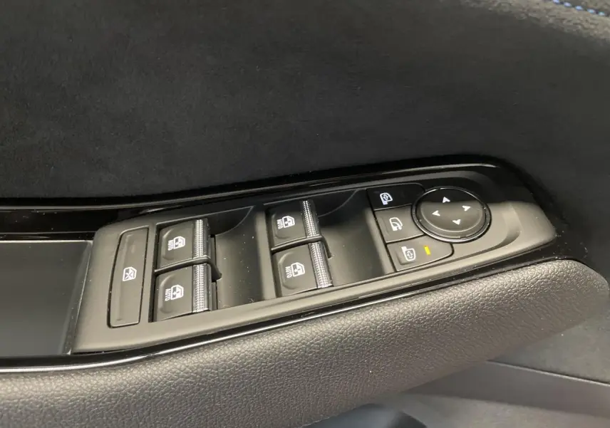 Gros plan sur les commandes de lève-vitres et rétroviseurs côté gauche en finition noire Alcantara du Renault Austral 2025.