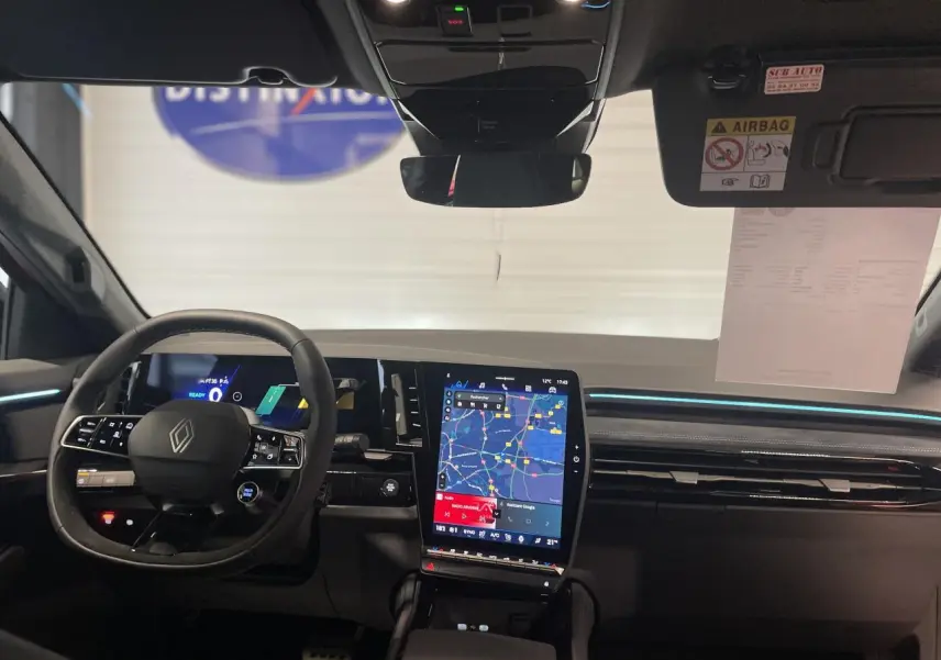 Vue intérieure avant du Renault Austral 2025 montrant le volant Alcantara et l'écran tactile vertical du système multimédia.