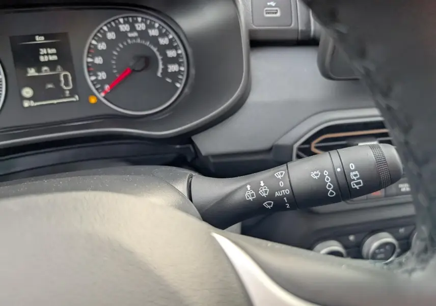 Gros plan sur la commande d’essuie-glace côté droit du tableau de bord gris d’un Dacia Jogger 2025.