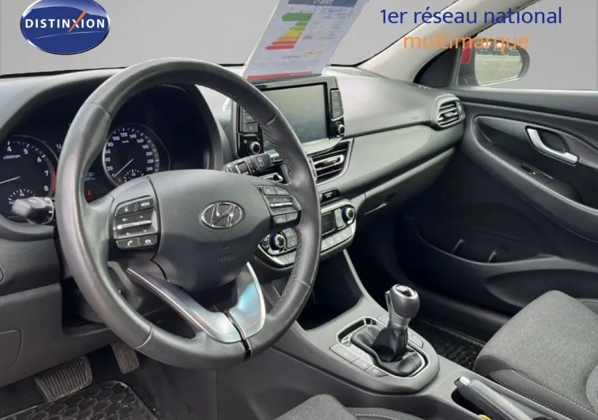 Vue intérieure côté conducteur du tableau de bord et volant en cuir noir de la Hyundai i30 SW 2023.