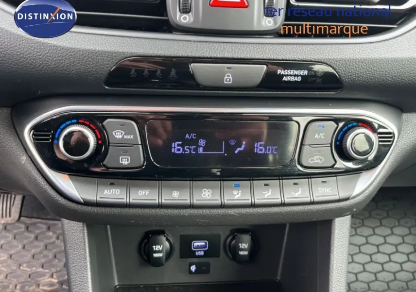Vue rapprochée du tableau de bord de la Hyundai i30 SW 2023, montrant la console de climatisation digitale et les ports USB et 12V.