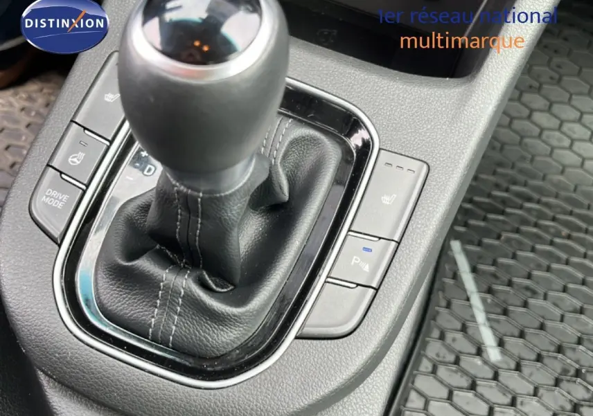 Gros plan sur le levier de vitesses automatique en cuir noir de la Hyundai i30 SW 2023, avec commandes chauffantes visibles.