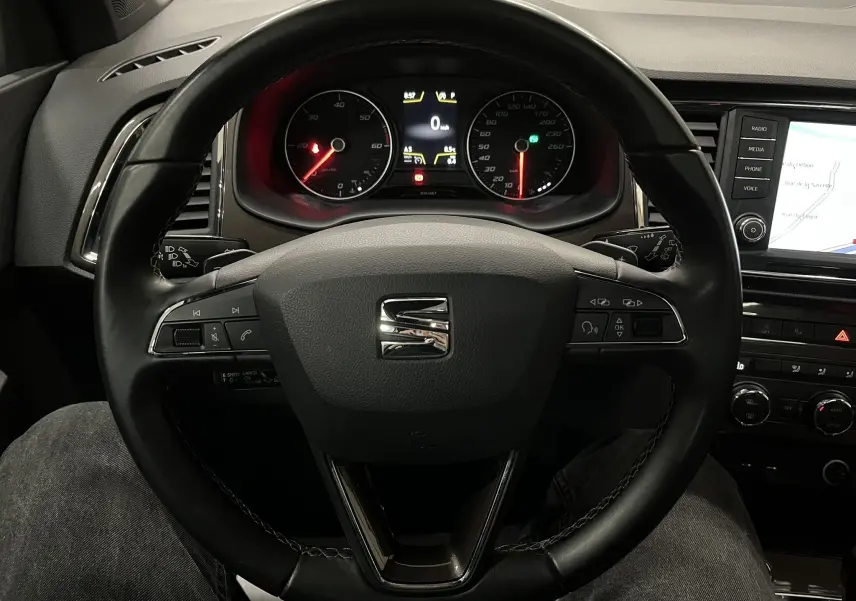 Vue intérieure centrée sur le volant noir du SEAT Ateca 2016 avec tableau de bord et écran multimédia visibles.