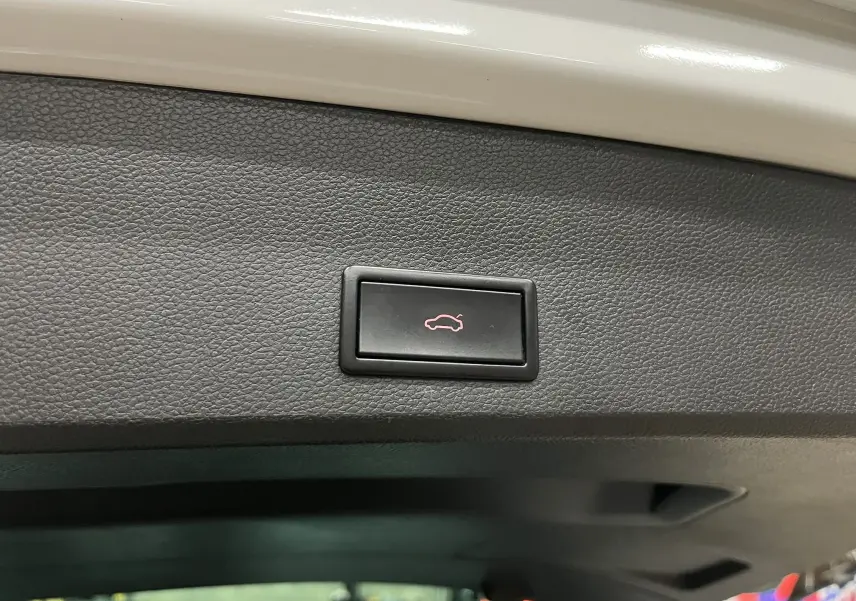 Bouton d'ouverture électrique du coffre sur la garniture intérieure du hayon d'un SEAT Ateca blanc.