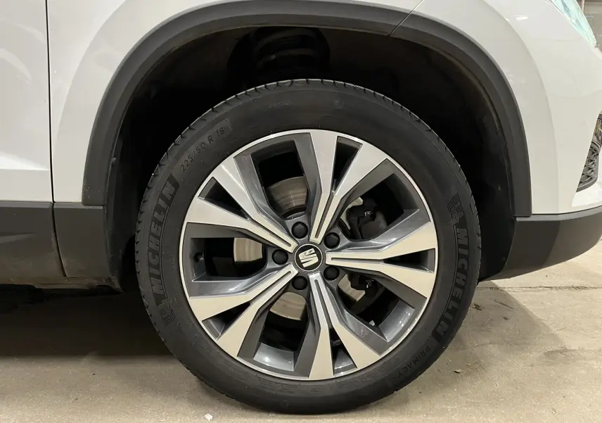 Gros plan sur la roue avant droite du SEAT Ateca blanc de 2016 avec jante alliage bicolore et pneu Michelin.
