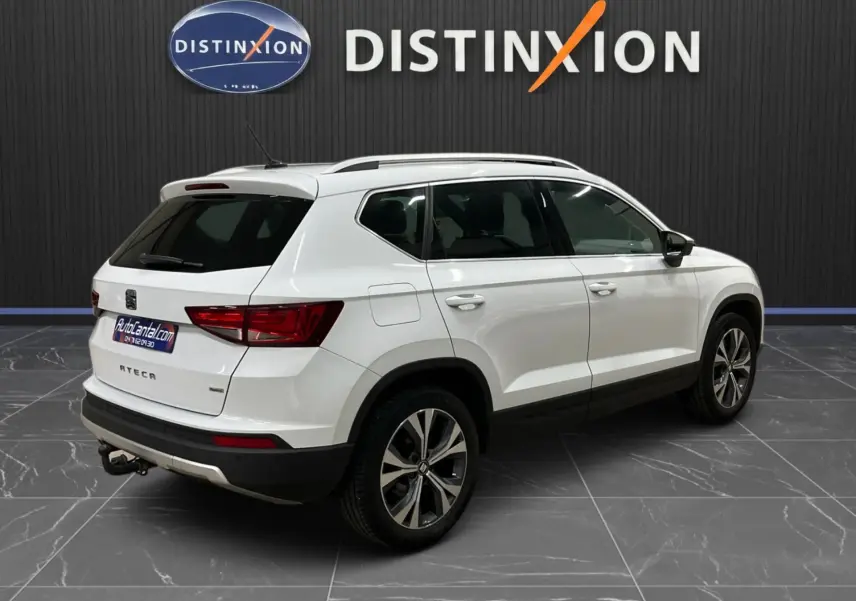 SEAT Ateca blanc en 3/4 arrière droit, SUV avec barres de toit et jantes alliage bicolores.