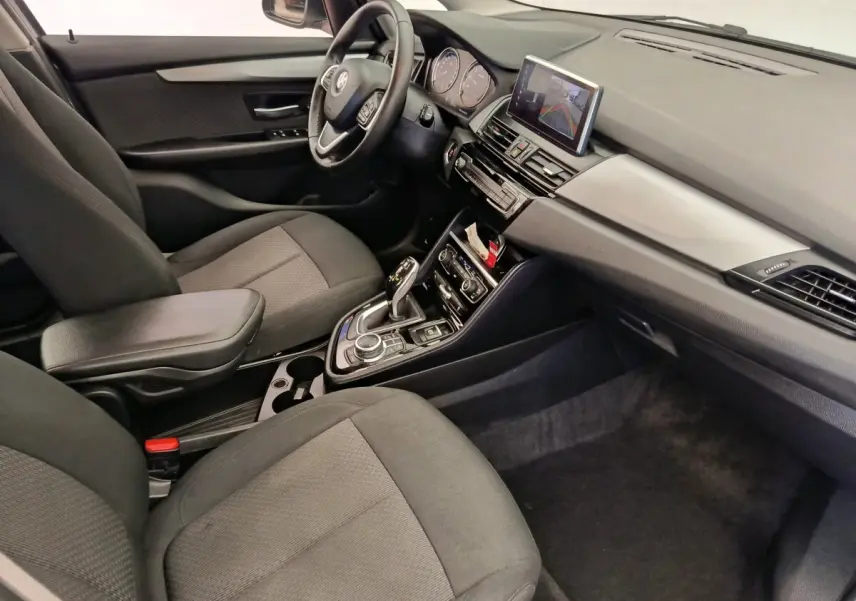 Vue intérieure côté conducteur de la BMW Série 2 Gran Tourer 218i Lounge 2022 avec sièges tissu gris et tableau de bord moderne.