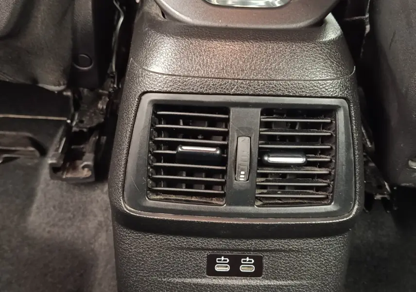 Vue rapprochée des aérateurs arrière et ports USB-C noirs dans l’habitacle d’une BMW Série 2 Gran Tourer gris clair.