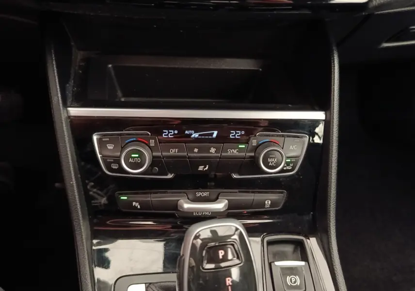 Vue rapprochée de la console centrale noire du BMW Série 2 Gran Tourer 218i Lounge avec commandes climatisation et levier de vitesse automatique.