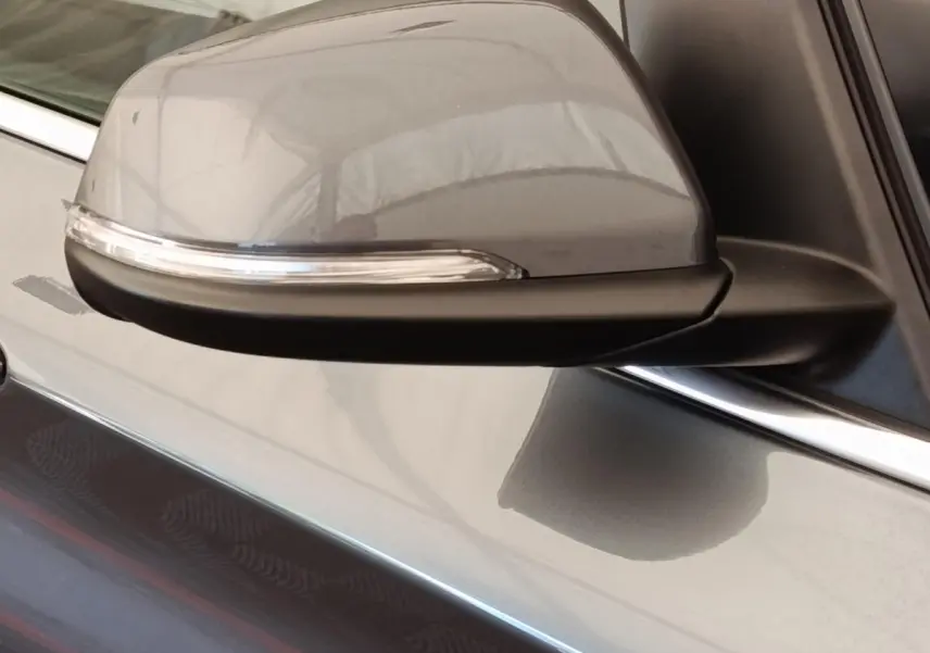 Gros plan sur le rétroviseur droit gris clair de la BMW Série 2 Gran Tourer F46 218i Lounge 2022 avec clignotant intégré.
