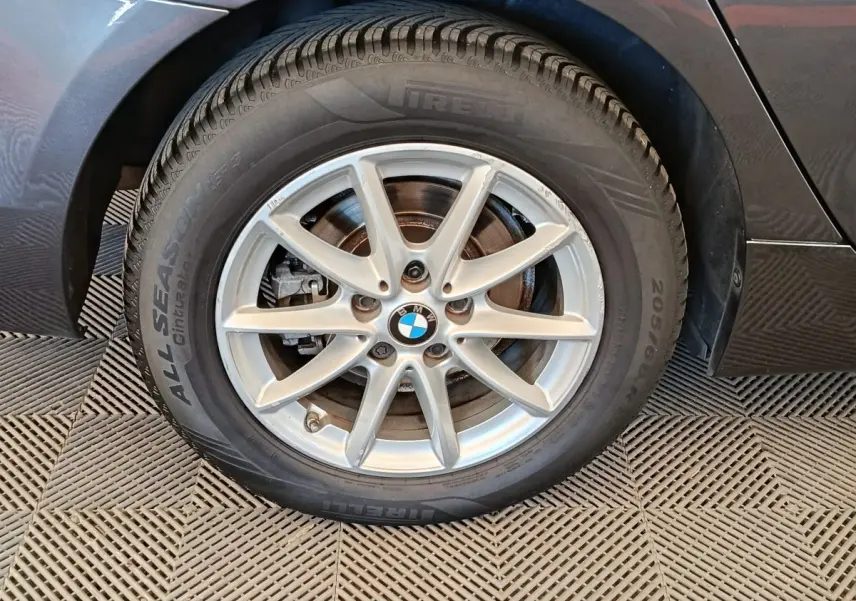 Gros plan sur la roue avant gauche grise claire d’une BMW Série 2 Gran Tourer F46 avec jante alu à 7 branches.