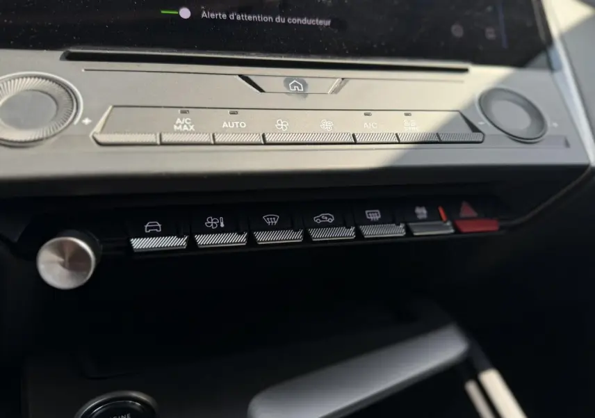 Gros plan sur la console centrale de la Peugeot 308 SW 2025, boutons de climatisation et démarrage sans clé visibles.