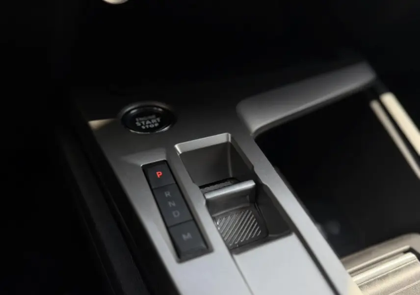 Gros plan sur la console centrale de la Peugeot 308 SW 2025, montrant la commande de boîte auto et le bouton start/stop.