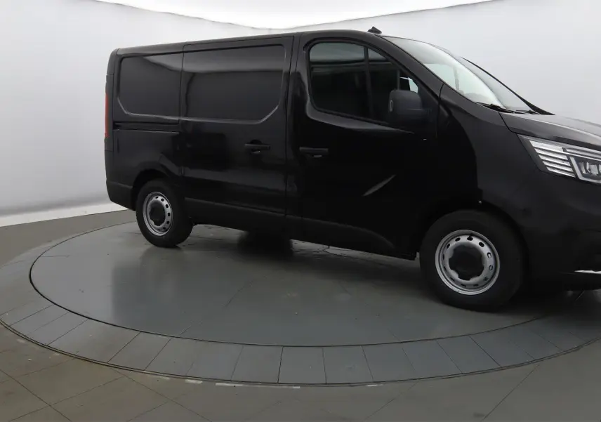 Renault Trafic Fourgon noir crépuscule en 3/4 avant droit, avec calandre chromée et phares LED visibles.