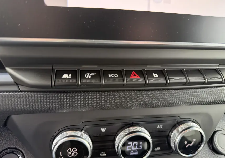 Détail intérieur du tableau de bord du Renault Trafic Fourgon noir, montrant les commandes climatisation et boutons fonctionnels.