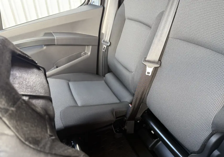 Vue intérieure côté droit du siège passager en tissu gris du Renault Trafic Fourgon noir crépuscule, avec ceinture de sécurité visible.