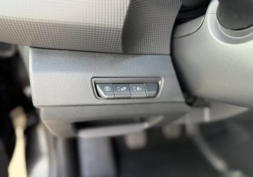 Gros plan sur les boutons de réglage du tableau de bord noir du Renault Trafic Fourgon 2025, côté gauche du conducteur.