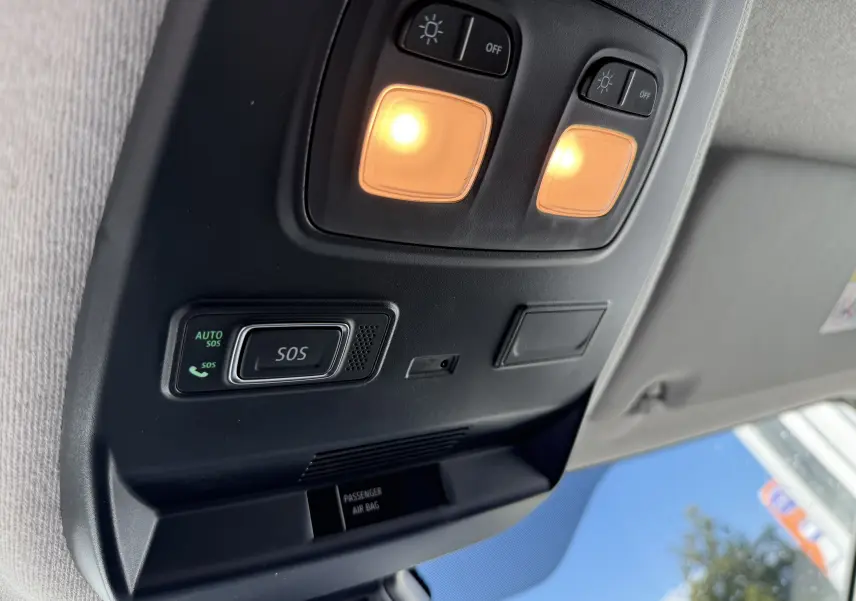 Vue intérieure en plongée du plafonnier noir avec éclairage et bouton SOS du Renault Trafic Fourgon 2025 noir crépuscule.