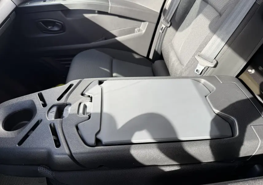 Vue rapprochée de la console centrale et siège passager tissu gris à l’intérieur du Renault Trafic Fourgon noir crépuscule.