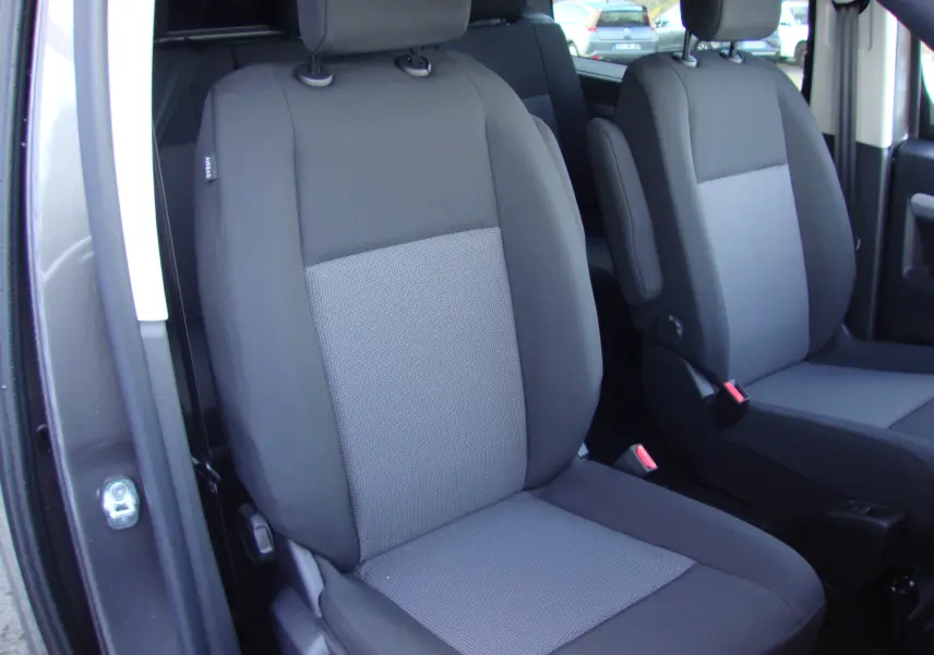 Gros plan sur les sièges avant gris du Citroën Jumpy Cabine Approfondie XL 2024, porte ouverte côté gauche.