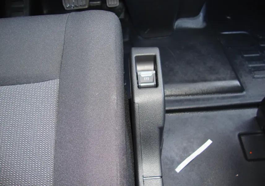 Gros plan sur le frein à main électrique et le siège conducteur en tissu gris du Citroën Jumpy Cabine Approfondie 2024.