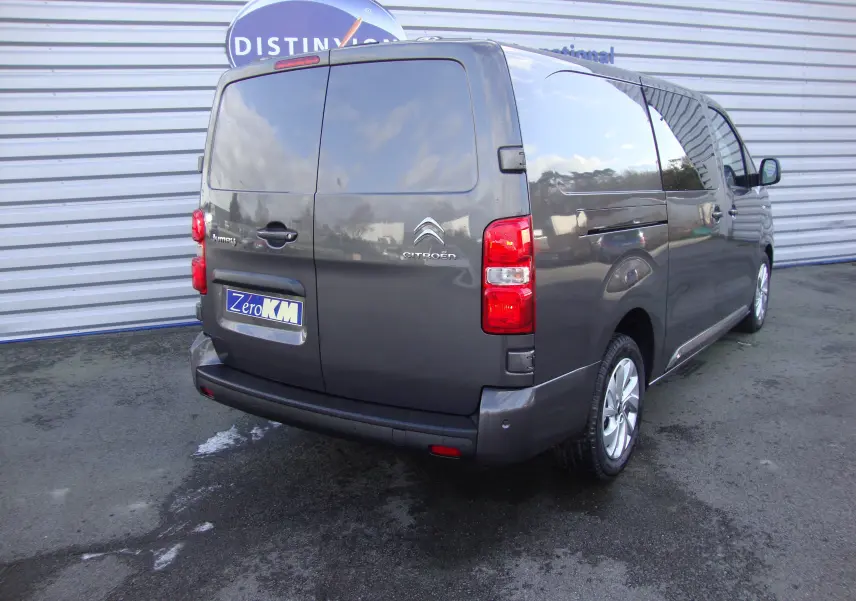 Vue 3/4 arrière droite d'un Citroën Jumpy cabine approfondie gris platinum avec portes arrière battantes et feux rouges visibles.