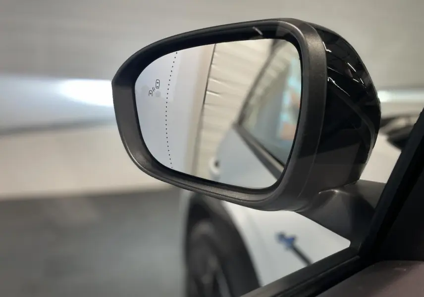 Rétroviseur extérieur droit noir brillant du Renault Austral blanc nacré satin avec toit noir étoilé, vue rapprochée.
