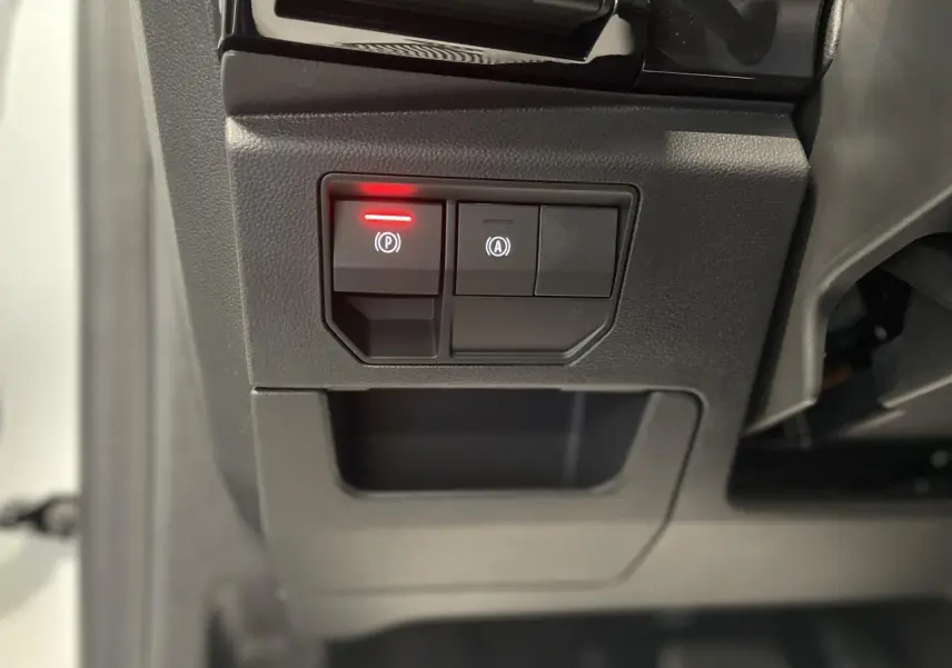 Gros plan sur les commandes du frein de parking électrique et du démarrage automatique dans un Renault Austral blanc nacré.