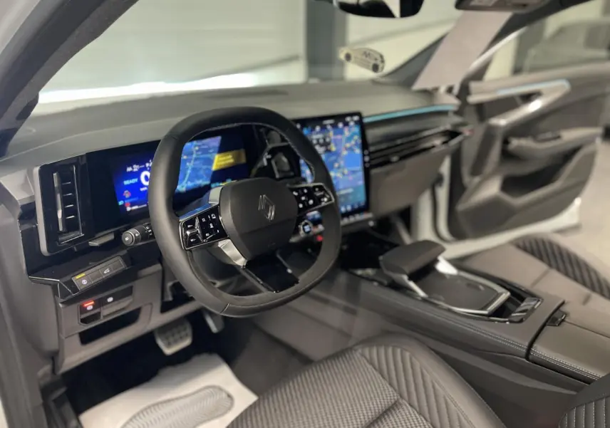 Intérieur Renault Austral 2025 vu côté conducteur, volant Alcantara, écran tactile vertical et sellerie tissu carbone.