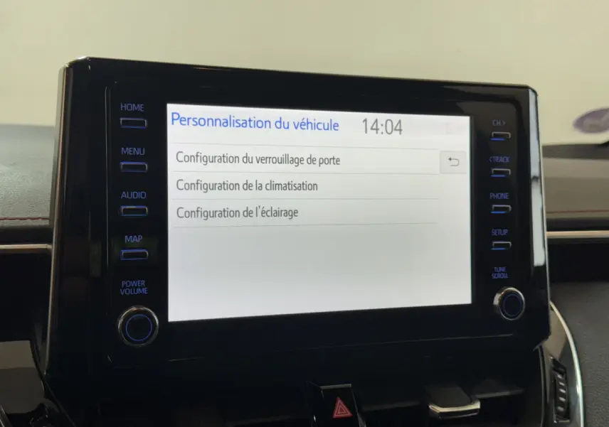 Écran tactile central affichant les options de personnalisation du véhicule dans une Toyota Corolla hybride gris clair.