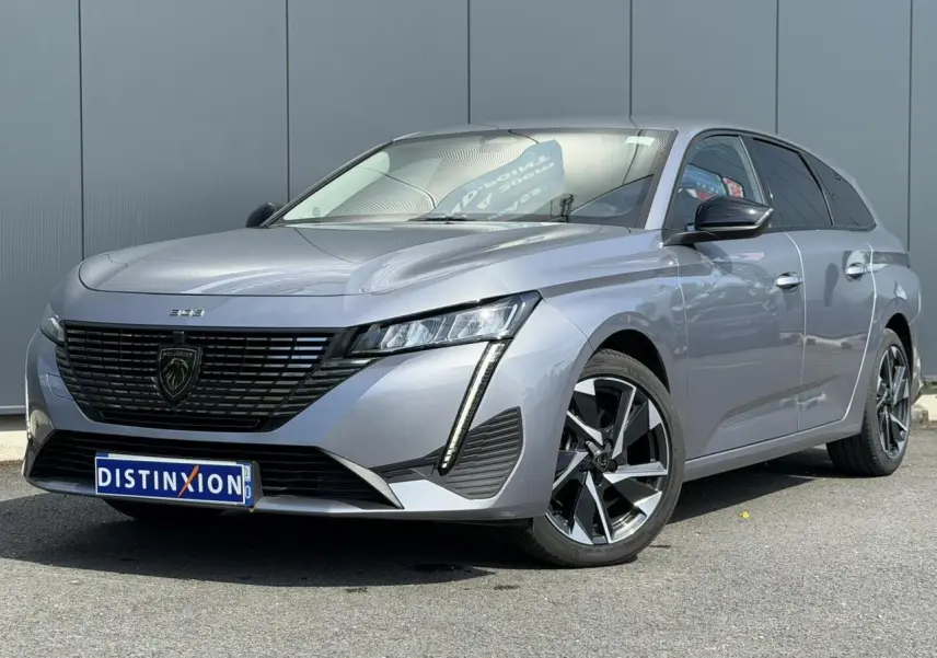 Peugeot 308 SW gris Artense en 3/4 avant droit, avec calandre noire et jantes alliage 17 pouces.