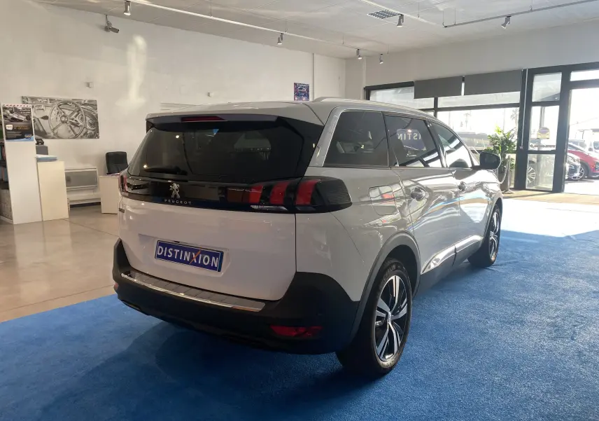 Peugeot 5008 blanc blanquise vue 3/4 arrière droit en showroom avec attelage neuf et jantes noires.