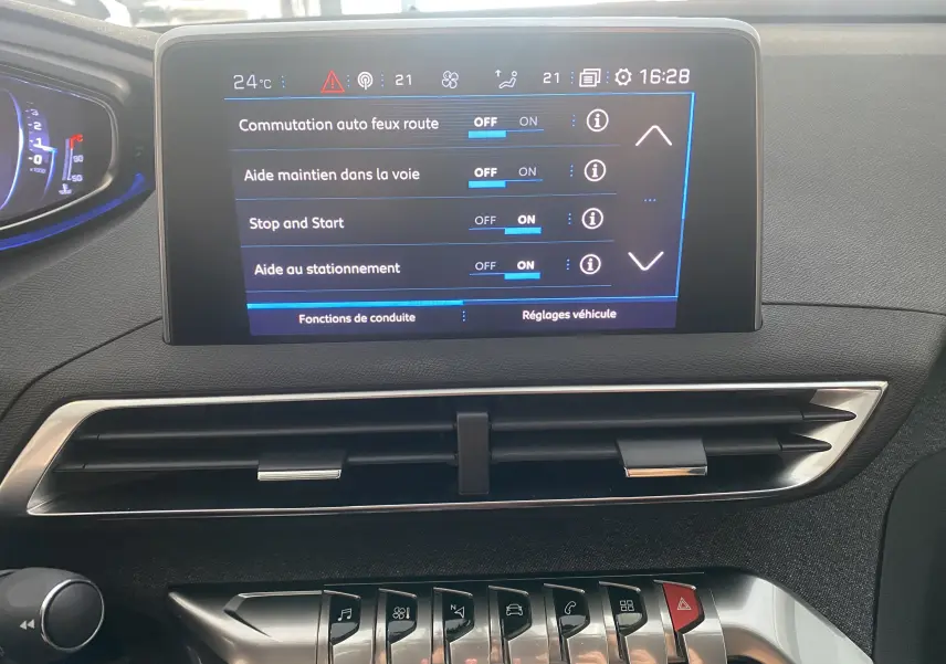 Écran tactile central du tableau de bord du Peugeot 5008 blanc, affichant les réglages d'aide à la conduite.