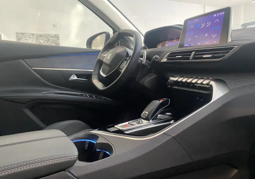 Intérieur du Peugeot 5008 blanc, vue côté conducteur sur le tableau de bord et la console centrale avec écran tactile.
